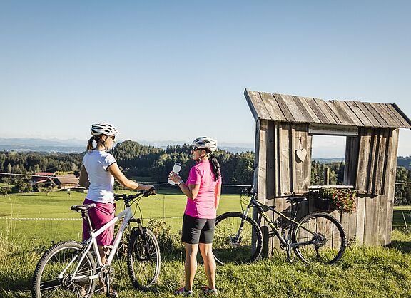 Zwei Radlerinnen vor hügelliger Landschaft